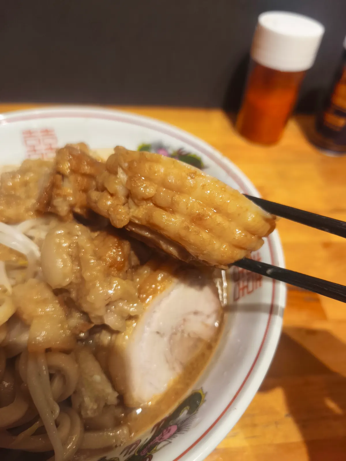 箸で持ち上げた、ブタゴリラの大きな豚。表面に格子状の切れ目が入り、脂がとろりと光っている。崩れそうなほど柔らかい