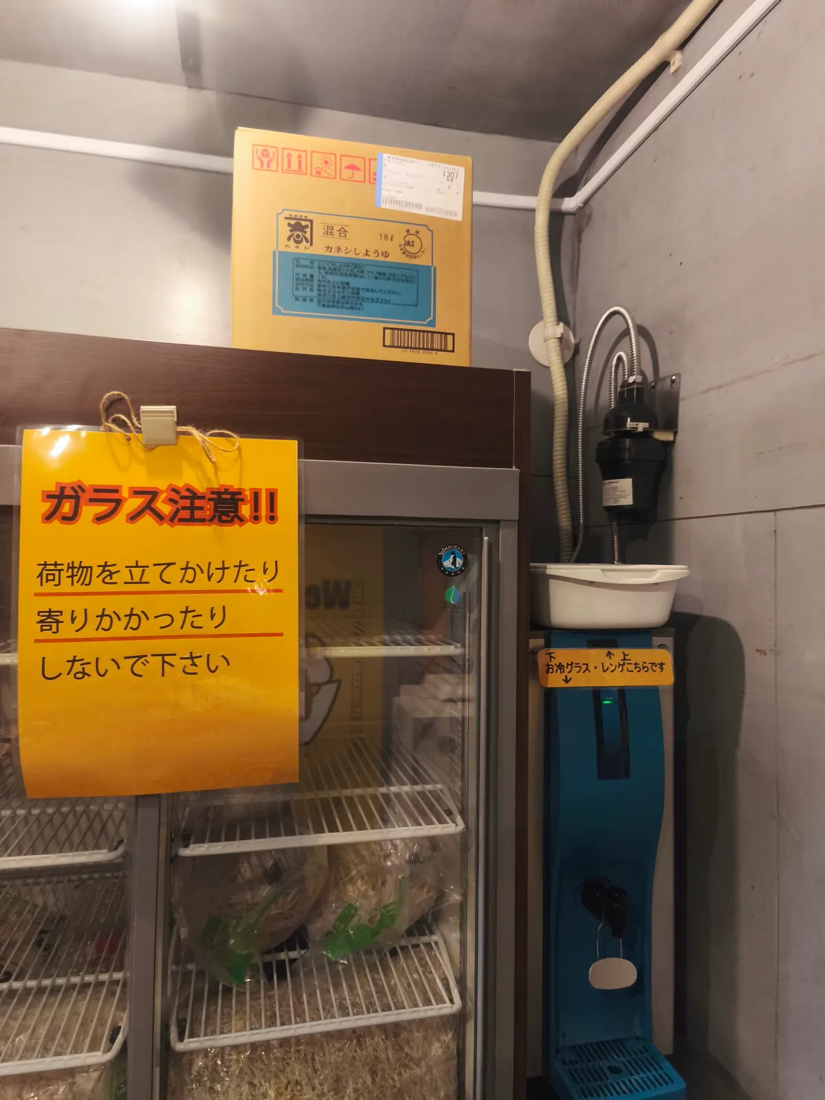 段ボール箱に「カネシしょうゆ」と印字された、二郎系でおなじみのカエシ用醤油。店内の冷蔵庫の上に置かれていた