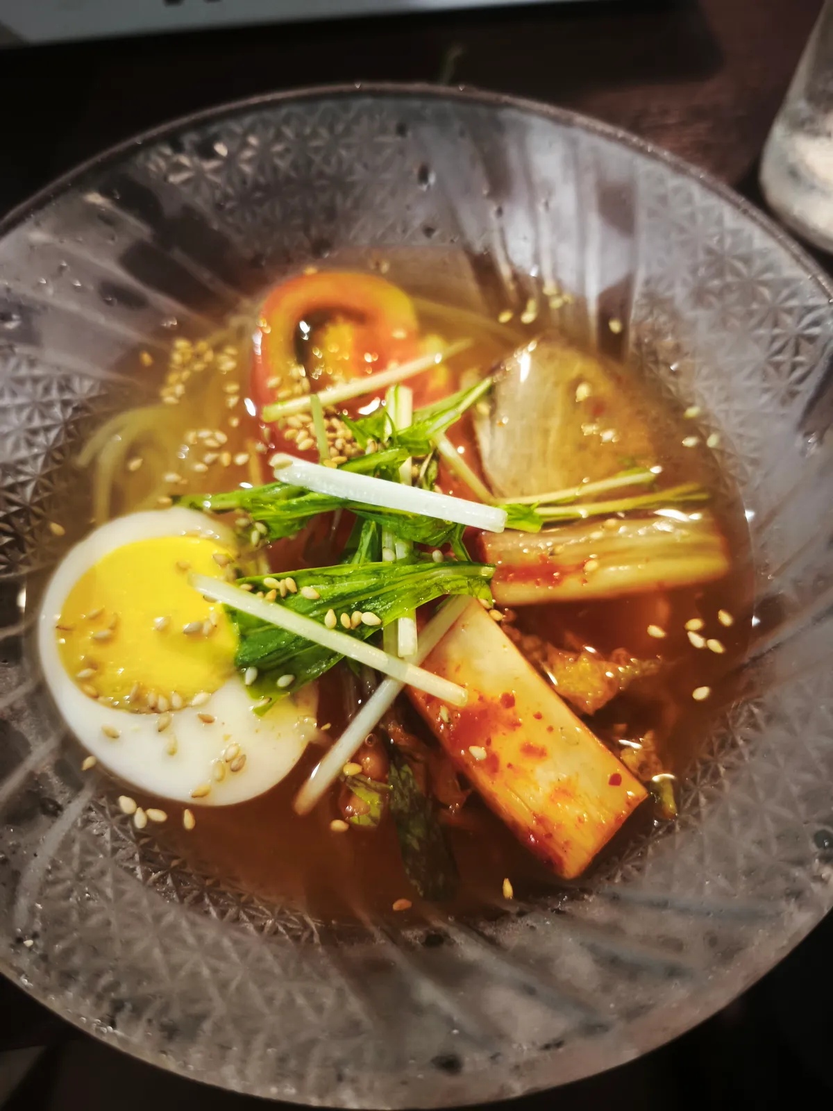 冷麺。ゆで卵・トマト・キムチ大根がのっている