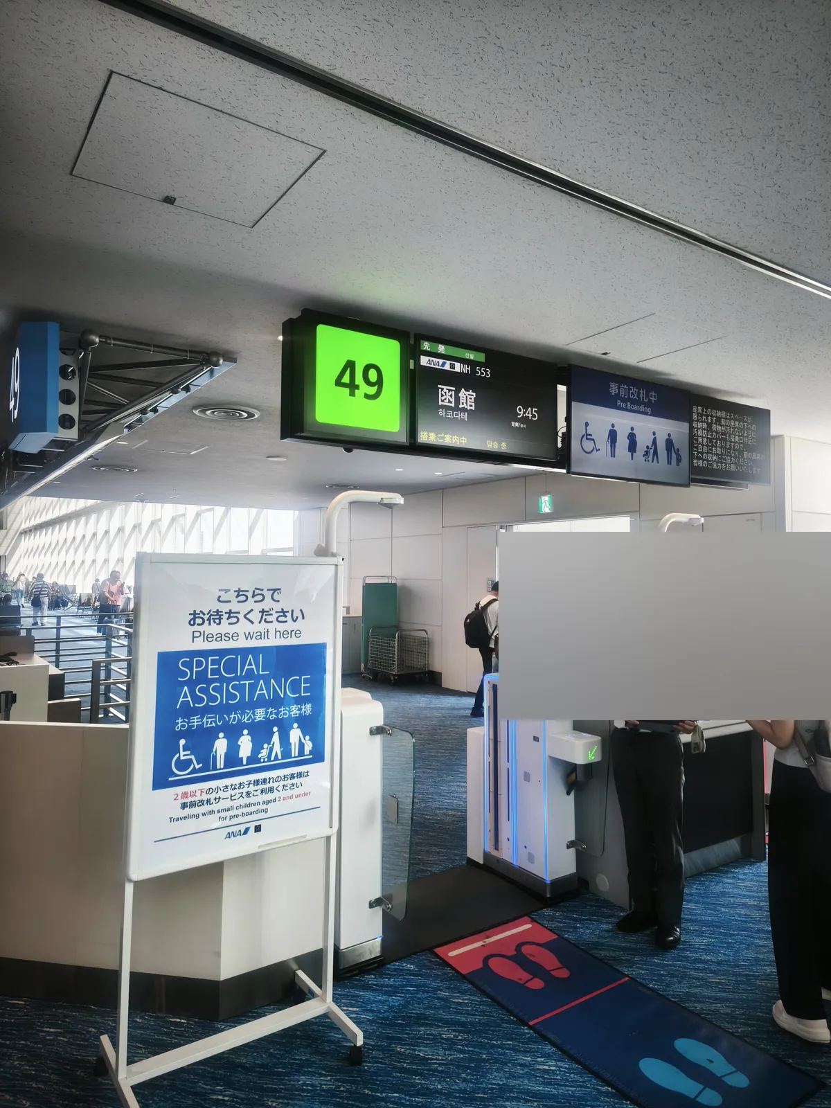 搭乗ゲートの案内表示。49番ゲート、ANA NH553、函館、9:45と表示されている
